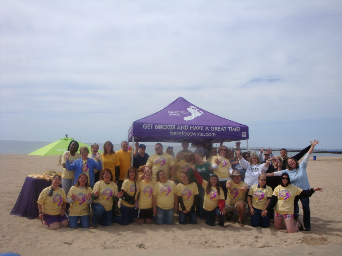 Volunteers celebrate clean beaches at a Barefoot Wine & Bubbly Adopt-a-Beach event.