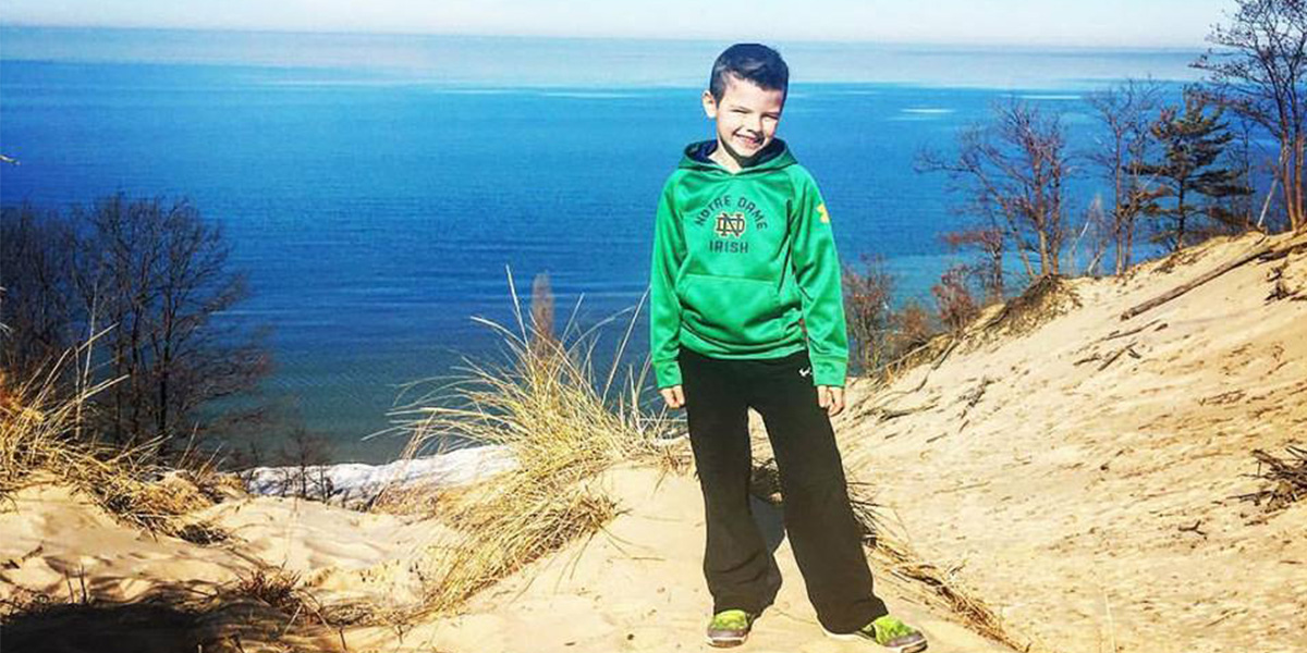 Noah Albert atop a sand dune on the shores of Lake Michigan