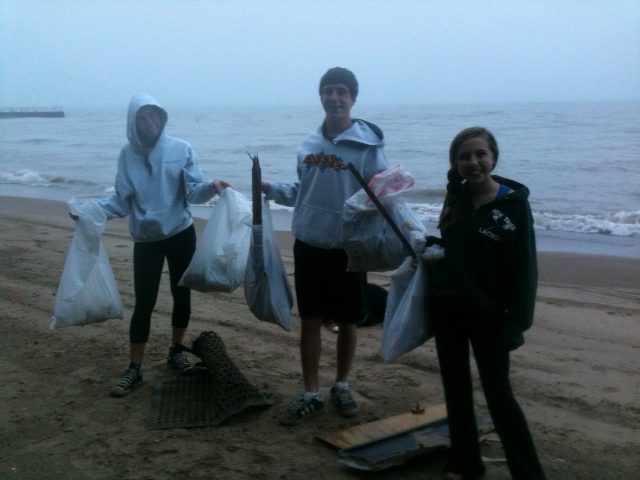 Three of Tor Solberg's five children cleaning up Maple St. Beach in Winnetka, Illinois.