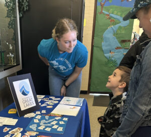 A woman engages a child in a Great Lakes activity.